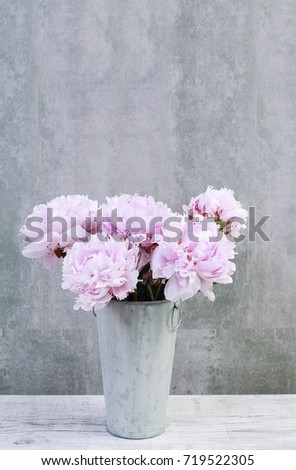 Bouquet of pink peonies on grey stone background, copy space.