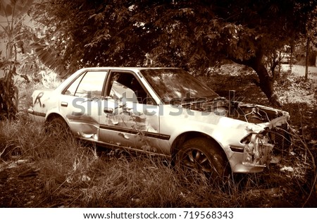 Old Rusty Car Wreck in Scary Junk Yard / Loneliness and Mysterious Concept / Halloween Theme /  Sepia with Vignette Effect 
 Royalty-Free Stock Photo #719568343