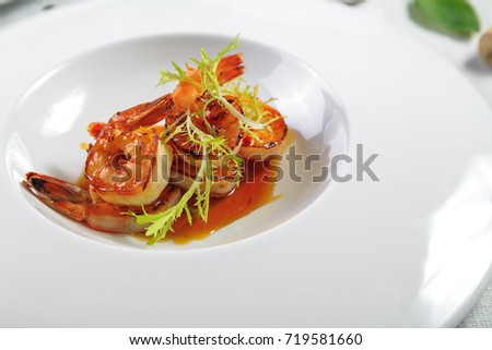 Grilled tiger prawns in white plate with lemon and spices on vintage grey background, top view, copy space. Stone kitchen table with seafood dinner. Slow food concept