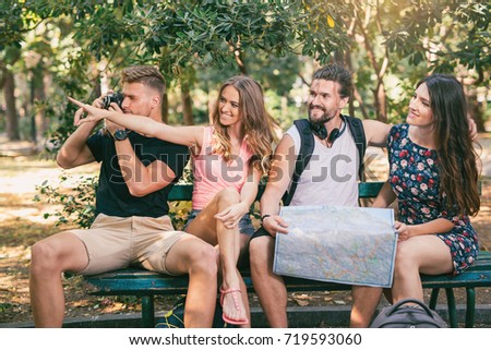 Young people tourists searching for direction using paper map