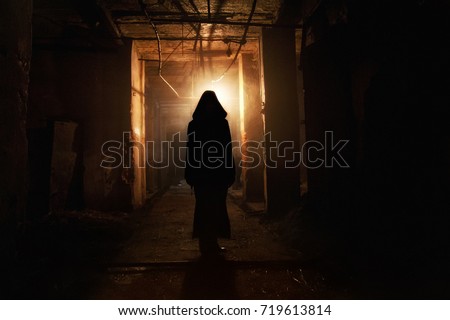 Creepy silhouette in the dark abandoned building. Horror about maniac concept  