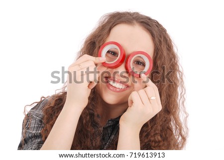 Portrait of a funny young girl looking at camera through insulating tape isolated on a white background