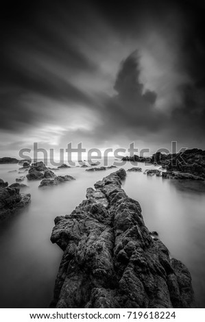 Tropical rocky beach at sunrise in black and white (nature landscape) long exposure photography