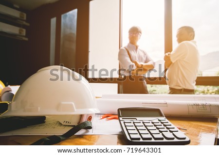 Close up ,calculator,white hat engineers.Two Architects meeting work in the office background.Selective Focus