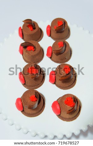 Sweet colored cakes in a plate on a white background