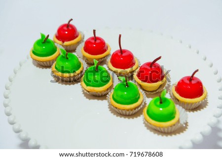 Sweet colored cakes in the form of an apple in a plate on a white background