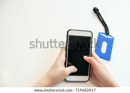 Woman hand holding the smart phone and identification Card,  Blue employee card on white background.