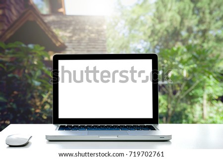 Conceptual Design,Empty workspace on desk white with Laptop screen and wireless mouse at blurred background of house.