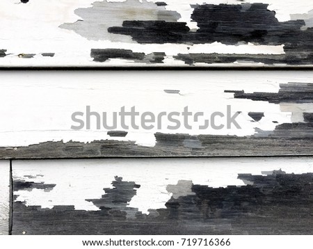 Close up detail of a rustic siding wall with peeling paint on a run down barn