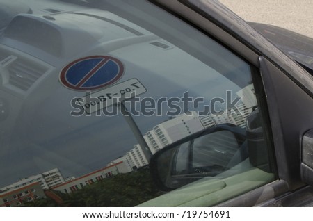 Parking sign reflect in car window