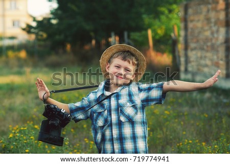 A little boy with an old camera .Young cheerful photographer