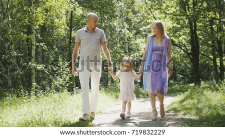 Happy family walking in the park at sunny day