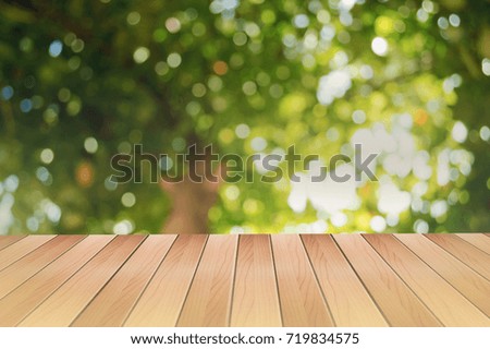 Brown empty wooden table with green leaves abstract bokeh background for product display or copy space for place your product.