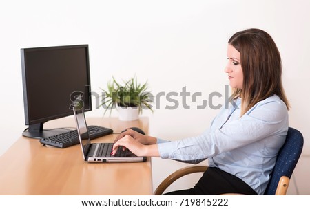 Cute young woman working on notebook in the office