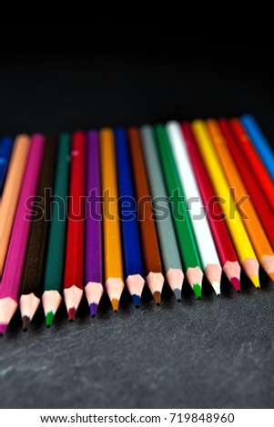 Colored pencils on a black stone slate