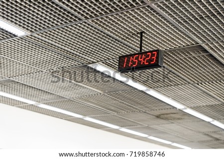 Digital LED clock with red light hanging on the ceiling in the airport