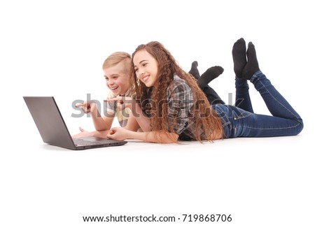 Boy and girl using a laptop lying on the floor isolated on white background