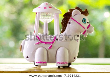 Toy horse in beautiful green nature blurry background