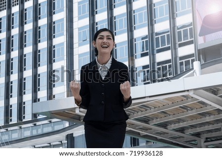 Happy confidence business woman front of the office building congratulation with success business.