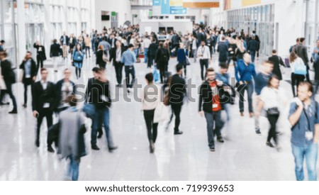 anonymous blurred people walking in a modern hall of a Exhibition
