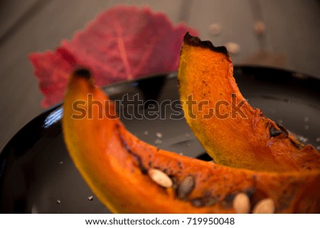 Roasted pumpkin slices and autumn leaves / Autumn concept