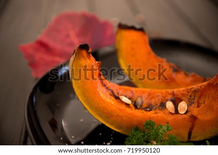 Roasted pumpkin slices and autumn leaves / Autumn concept