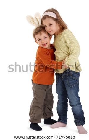 Cute kids hugging, smiling at camera, little boy wearing funny bunny hair band.?