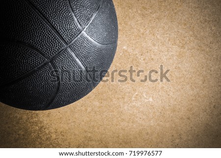 Old, black basketball ball on the floor. Sport activity. Sport concept. Close up. Vintage retro style and atmosphere. Empty place for a text.