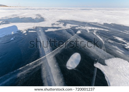 Winter landscape. Blue ice and snow, rock and coast of lake Baikal