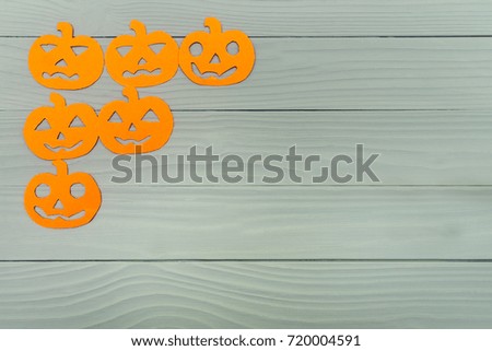Corner frame on the left side with different pumpkin paper silhouettes on a gray wooden table. Halloween celebration. Copy space for greetings
