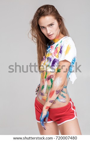 beautiful seductive woman is dirty in multicolored paint.