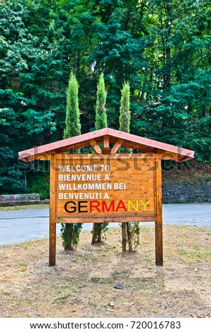 wooden signboard that announces the welcome in Gemany to tourists and friends