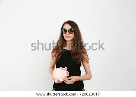 Pig piggy bank and coins, A beautiful girl is holding a piggy bank in her hands,
