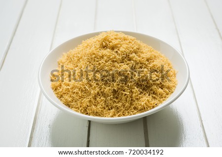 stock photo of Sev Namkeen Food Aloo Sev also know as namkin and nimco a popular crisp savory snack made from mashed potatoes, chickpea flour and spices, isolated over white background
