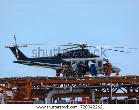 Helicopter or chopper land at oil and gas platform area for get and sent passenger from onshore hangar to offshore platform. Crew change working rotation by helicopter.                           Royalty-Free Stock Photo #720042262