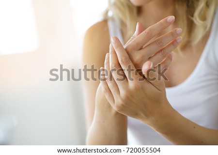 Closeup on woman's hands applying moisturizing hand-cream on Royalty-Free Stock Photo #720055504