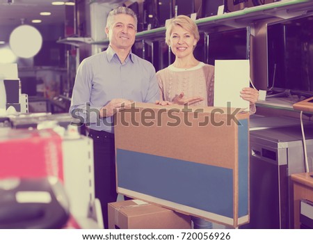 Charming mature married couple are happy buying on credit household appliances for home