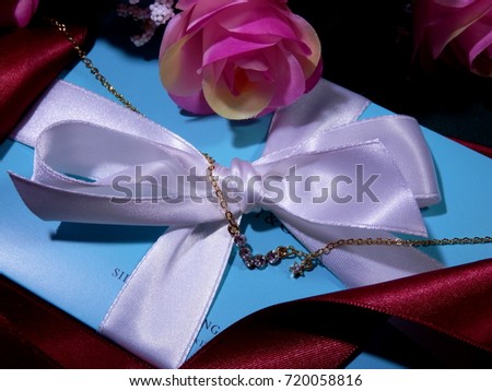 A bouquet of the rose and ribbon and necklace