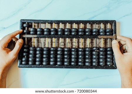 Man's hands accounting with old abacus and hold electronic calculator. picture financial concept design. 