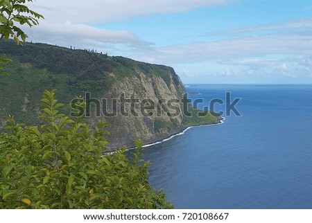 Scenic mountain side cliff leading to turquoise blue ocean water 