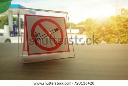 No smoking sign in the gas station put on the wooden table.