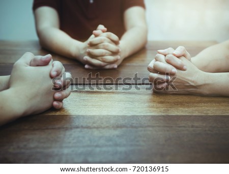 Christian bother and sister are praying together on wooden table ,small  prayer group in church, christian background with copy space for your text.
