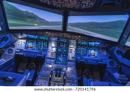 A view of the cockpit of a large commercial airplane, a cockpit trainer. Cockpit view of a commercial jaircraft cruising Royalty-Free Stock Photo #720141796
