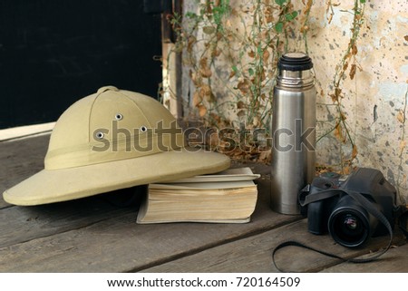 still life with  traveler's things: hat, book, thermos, camera.