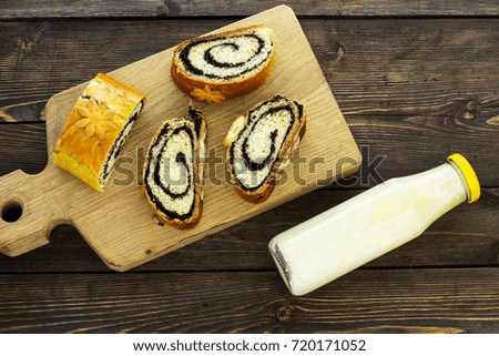 Sweet pastries. Roll with poppy seeds. Wooden background.