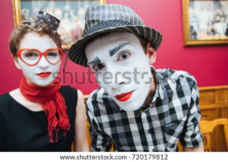 two mimes showing emotions on the wall background