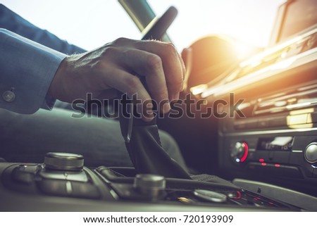 Car Driving Concept. Driver Shifting To Drive Mode. Hand on Transmission Stick Closeup Royalty-Free Stock Photo #720193909
