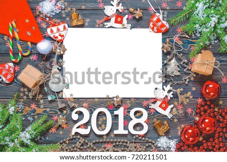 New Year's congratulatory hum noise with figures 2018 with winter and Christmas jewelry. The top view of board with snow, a tree, a cloth, spheres, the pine cone, decorating. The place for your text