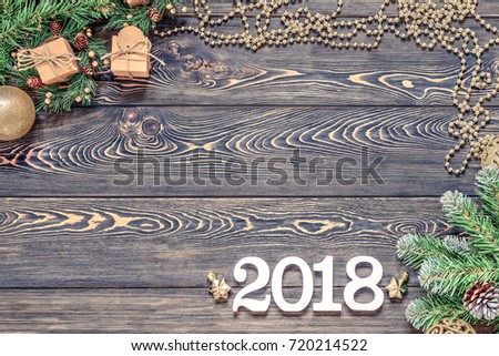Sigh symbol from number 2018 on vintage style wooden texture background. Happy New Year 2018 greetings on wooden. Dark background, branches of spruce with boxes of gifts, place for advertising, text