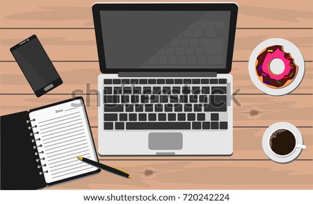 Laptop, note book with pen, coffee, donut and smartphone on wooden table